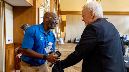 James Jacks shaking hands with an individual.